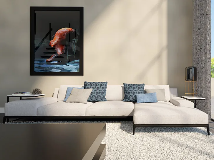 Zithoek met crème hoekbank, blauwe en gedessineerde kussens, donker omlijst kunstwerk en een hoogpolig vloerkleed.